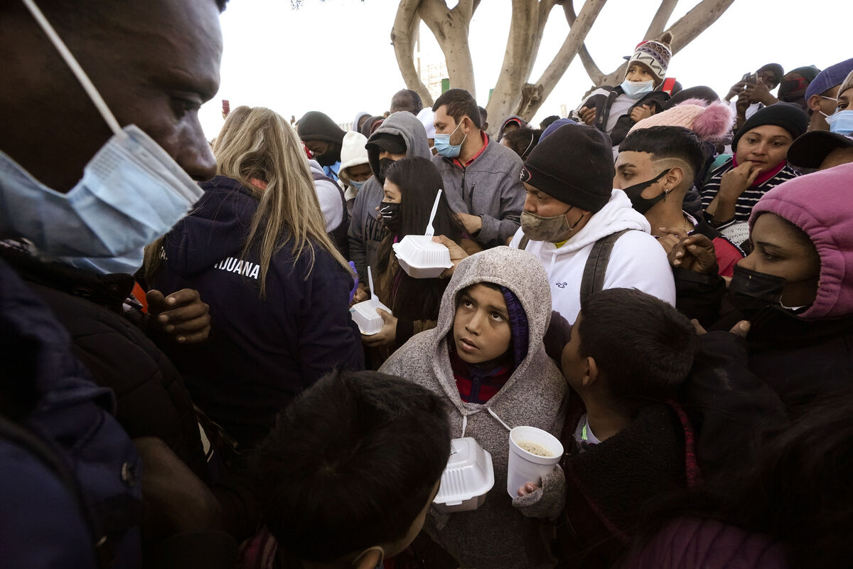 Asylum seekers receive food at the border near Tijuana after Biden’s loosening of some Trump-era immigration and border policies encouraged a record flow of migrants.  Picture: Gregory Bull/AP