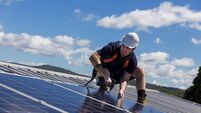 Solar panel installer with drill installing solar panels