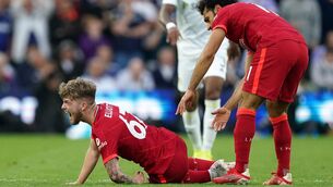 <p>Liverpool's Harvey Elliott calls out in pain as team-mate Mohamed Salah checks on his condition after picking up a bad injury at Elland Road</p>