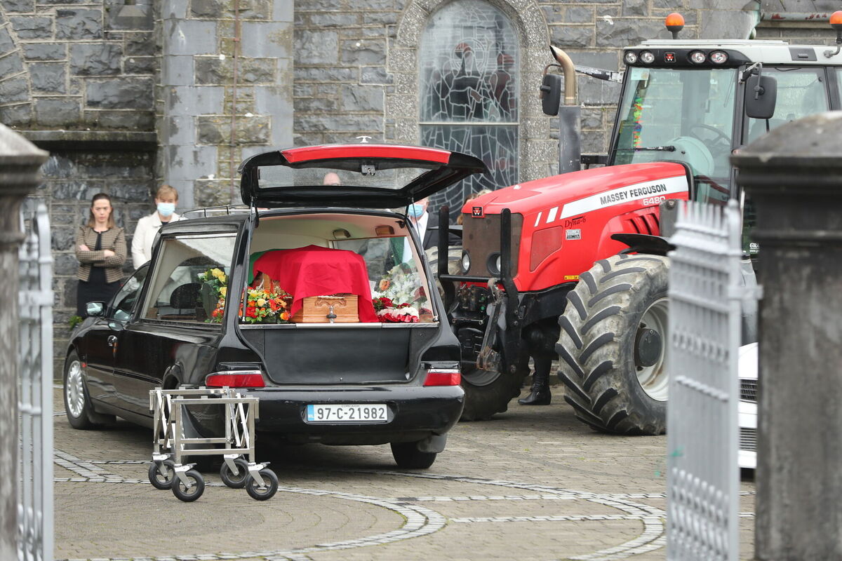 A Massey Ferguson tractor and Jamie's white car were parked outside the church as their coffins were brought in. Photo: Niall Carson/PA