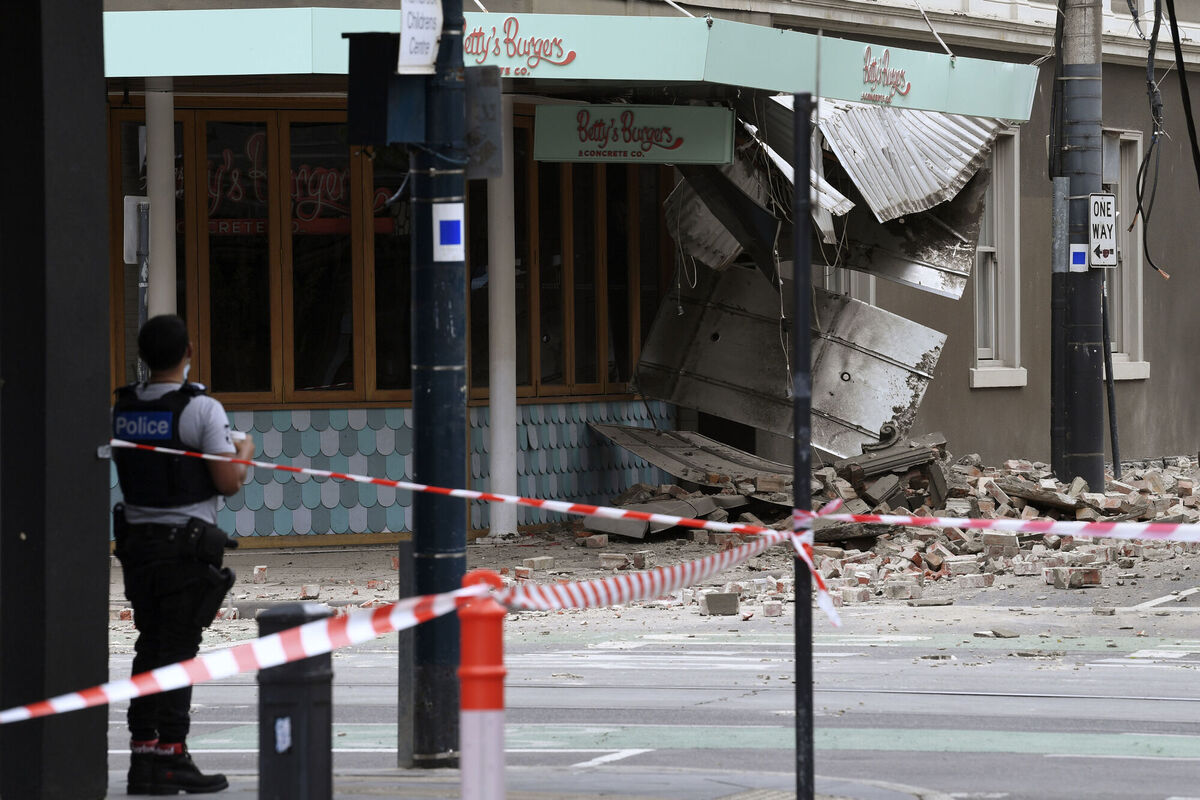 A police officer closes an intersection where debris is scattered in the road.