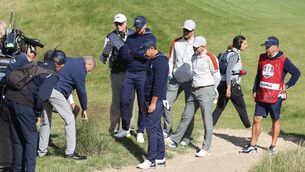 <p>A rules official inspects the lie of Brooks Koepka's on the 15th during Saturday's foursomes match against Europe's garcia and Rahm.</p>