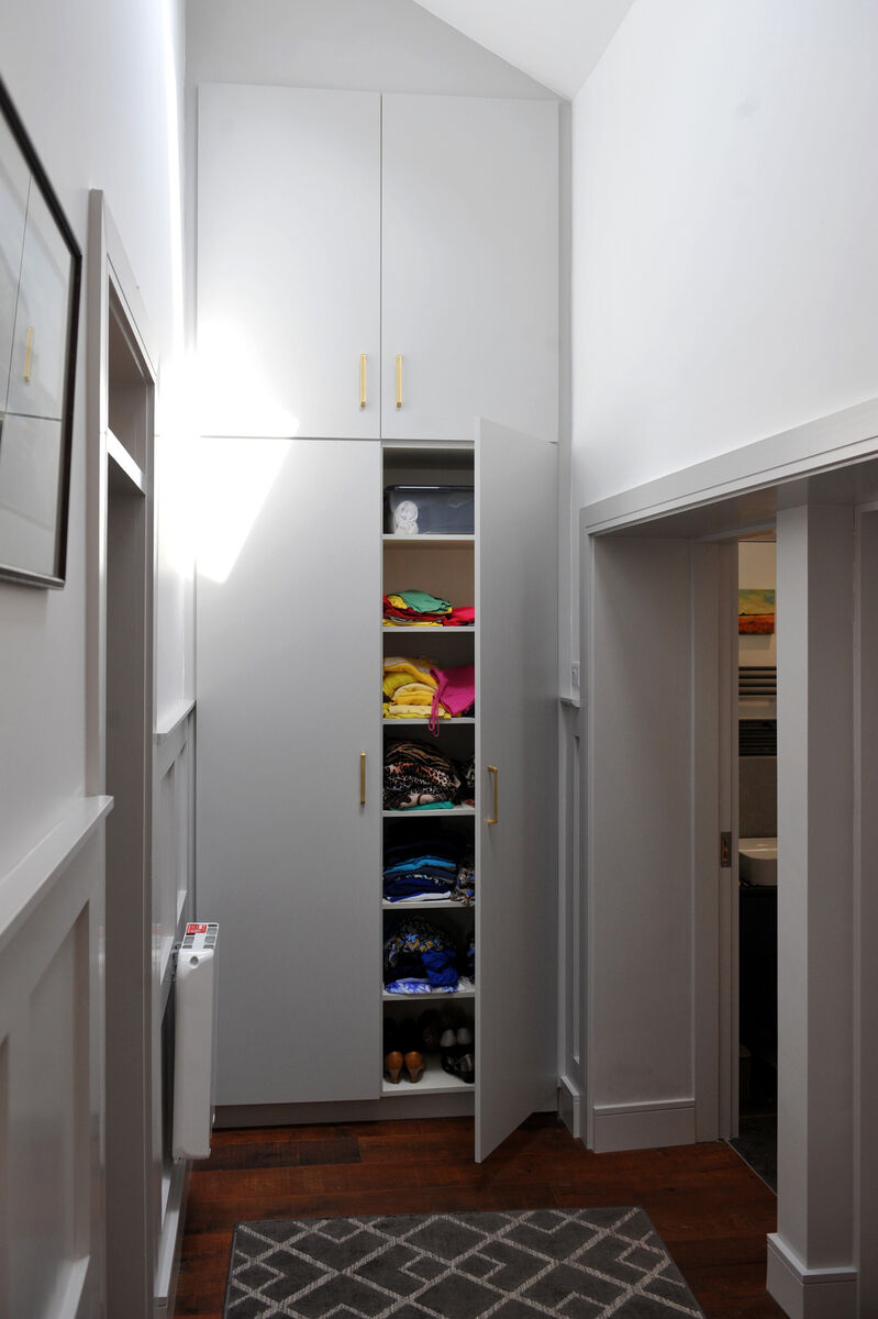Built-in storage is taken right up into the double-height ceiling with plenty of deep shelving to hide everything from linens to household clutter.