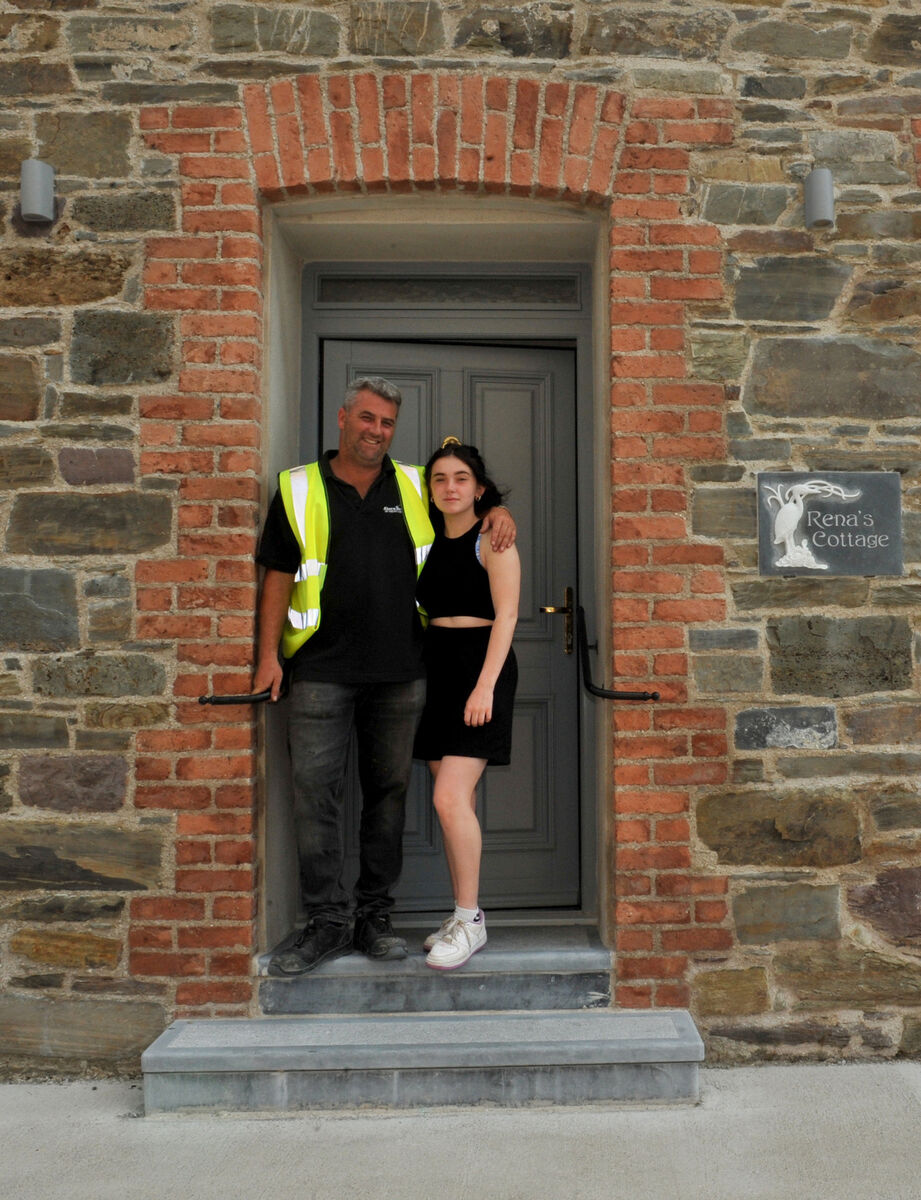  Stonemason Kieren Ahern of Ahern Bros, Youghal with his daughter Erin at the door to Rena's Cottage.