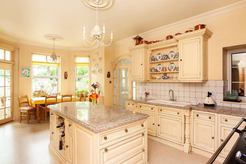 Sunny kitchen opens to a sun room with terrace and garden access