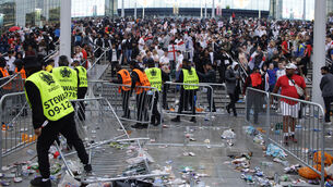 <p>Stewards replace barricades after they were knocked over by supporters outside Wembley during the Euro 2020 final (David Cliff/AP)</p>