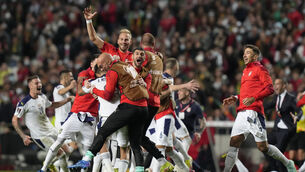 <p>Serbia celebrate victory in Portugal, which sealed their place at Qatar 2022 (Armando Franca/AP)</p>
