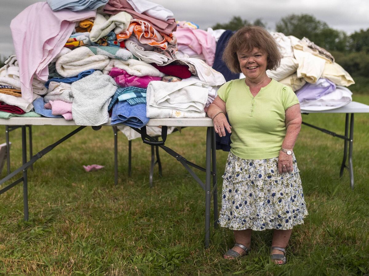 Mary with her sorting pile outside her home. 