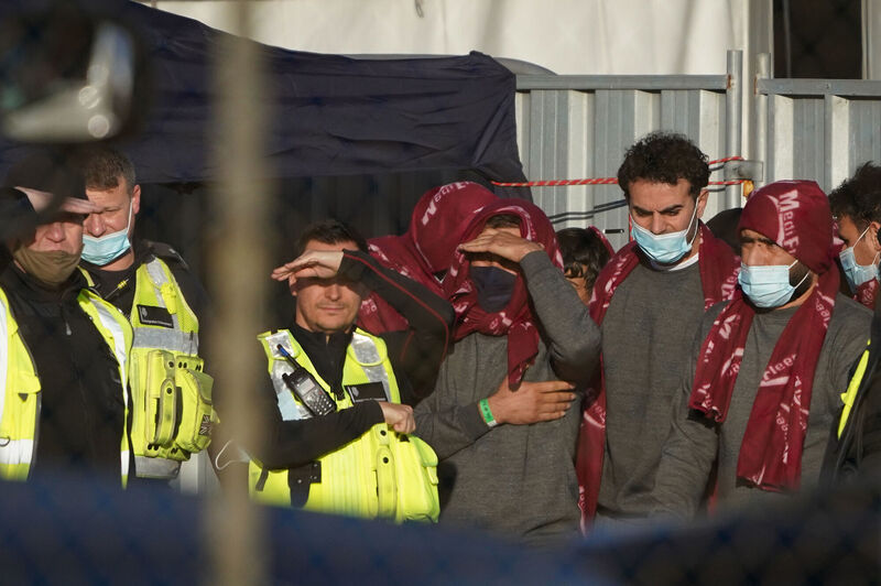 Migrants wait in a holding area after being brought in to Dover, Kent.