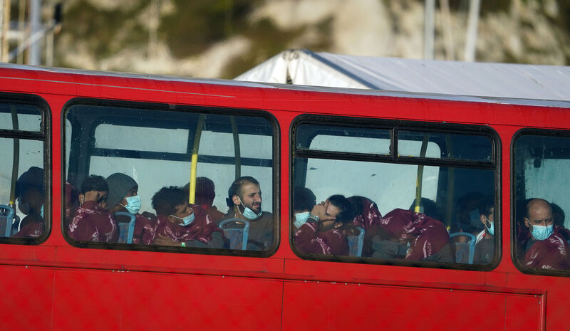 A group of people thought to be migrants wait on a holding bus after being brought in to Dover, Kent.