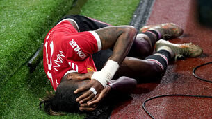 <p>Manchester United's Aaron Wan-Bissaka lies injured on the floor during the UEFA Champions League match </p>