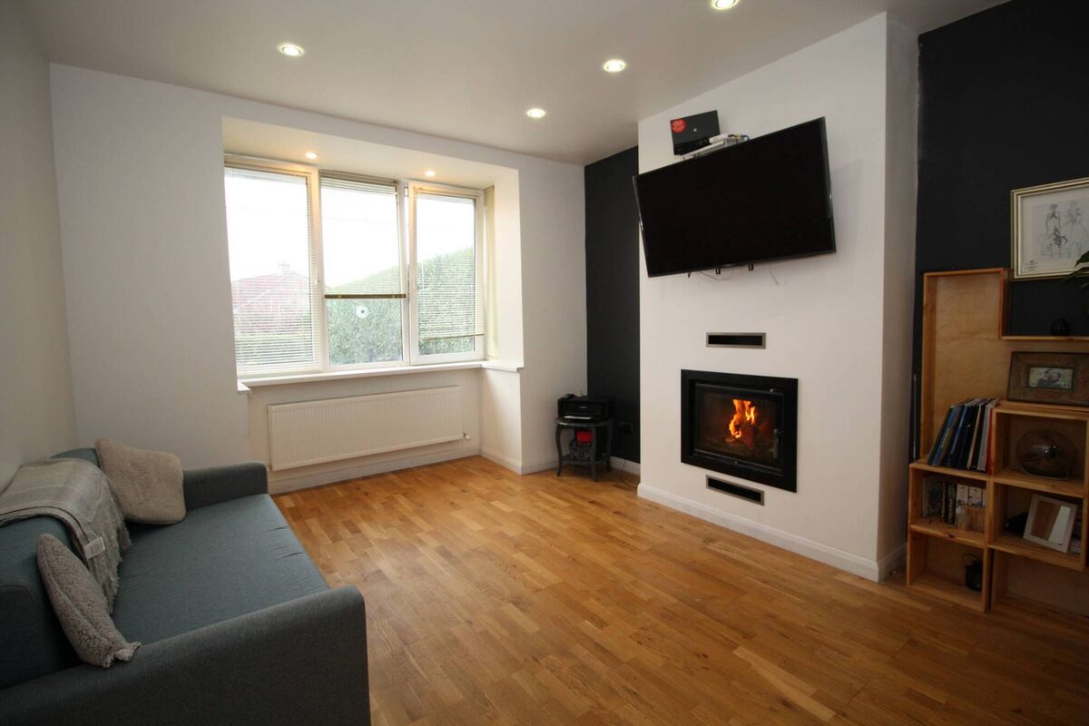 Living room with stove and bay window