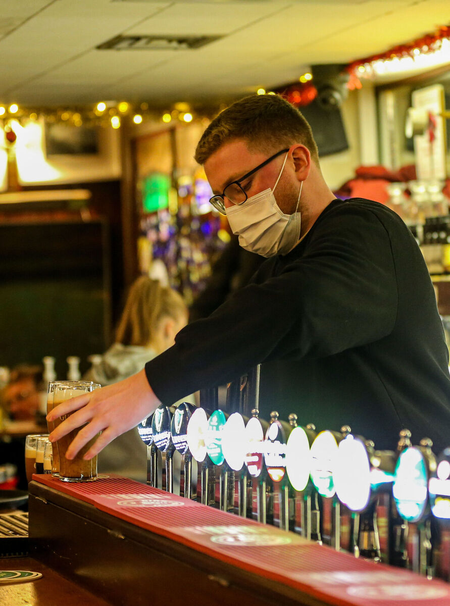 Daniel Smith of Grogans Bar serves drinks, ahead of a new 8pm closing time for pubs and restaurants. Picture: PA Daniel Smith of Grogans Bar serves drinks, ahead of a new 8pm closing time for pubs and restaurants. Picture: PA
