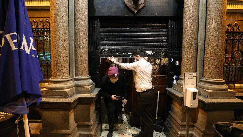 Staff pulling the shutters down and leaving the Stag's Head pub in Dublin. 