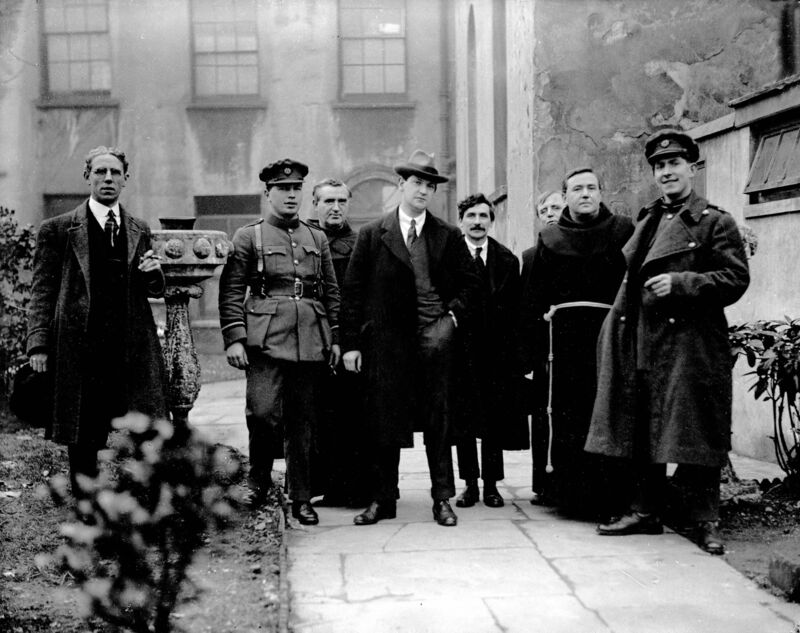 (Left to right) Diarmuid Fawcitt, Secretary Cork I.D.A., economic advisor during the Treaty negotiations and later a circuit court judge; Commandant Cooney, Michael Collins, T.D. Padraig O'Keeffe T.D., Fr Leo Sheehan, Very Rev. Fr Edmund Walsh and General Sean Mac Eoin at St Francis Church, Broad Lane, Cork, on Sunday, March 12, 1922, before the monster meetings at the Grand Parade. (Left to right) Diarmuid Fawcitt, Secretary Cork I.D.A., economic advisor during the Treaty negotiations and later a circuit court judge; Commandant Cooney, Michael Collins, T.D. Padraig O'Keeffe T.D., Fr Leo Sheehan, Very Rev. Fr Edmund Walsh and General Sean Mac Eoin at St Francis Church, Broad Lane, Cork, on Sunday, March 12, 1922, before the monster meetings at the Grand Parade.