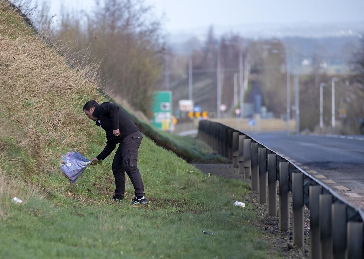 A relative of one of the victims places flowers at the scene this morning.