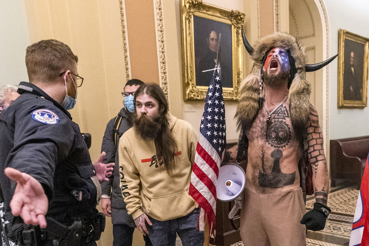 Supporters of President Donald Trump, including Jacob Chansley, right with fur hat, areconfronted by US Capitol police officers outside the Senate chamber this time last year. AP Photo
