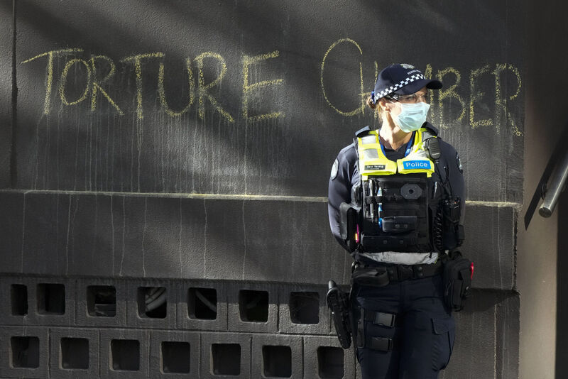 A police officer stands by a slogan on the wall outside the Park Hotel, used as an immigration detention hotel where tennis player Novak Djokovic is confined in Melbourne, Australia, Sunday, Jan. 9, 2022. Picture: AP Photo/Mark Baker