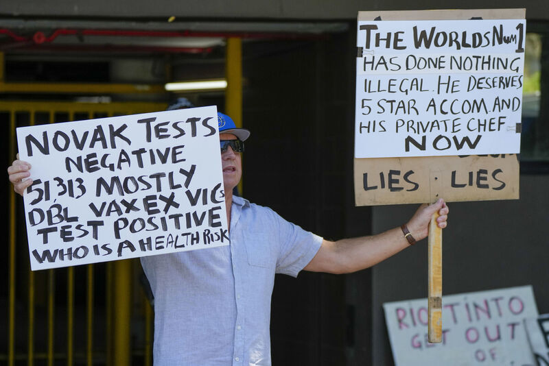 A supporter of Serbian Novak Djokovic holds placards outside an immigration detention hotel where Djokovic is confined in Melbourne, Australia, Monday, Jan. 10, 2022. Picture: AP Photo/Mark Baker