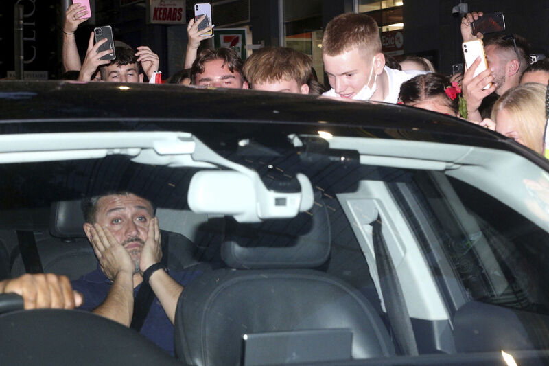 Fans of Serbian tennis star Novak Djokovic chase a car wrongly believed to be carrying him outside the Rialto building believed to be where he was located ahead of the Australian Open in Melbourne, Australia, Monday, Jan. 10, 2022. Picture: AP Photo/Hamish Blair)