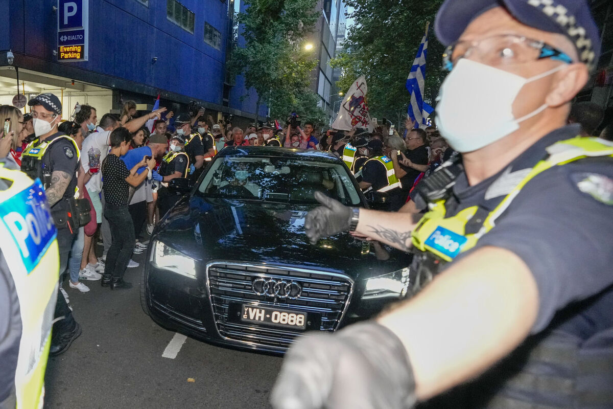Police clear fans of Serbian Novak Djokovic as a car leaves the offices of lawyers following his court win ahead of the Australian Open in Melbourne, Australia, Monday, Jan. 10, 2022. Picture: AP Photo/Mark Baker