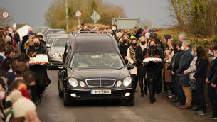 <p>Mourners walk beside the hearse as the cortege arrives at St Brigid’s Church, Mountbolus, Co Offaly (Niall Carson/PA)</p>