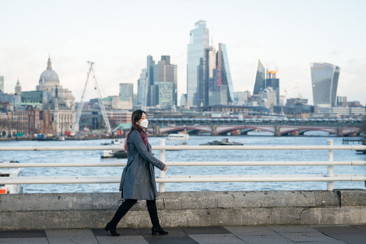 A woman wearing a face mask crosses Waterloo Bridge, London, after prime minister Boris Johnson announced that Plan B measures across England would be scrapped. 