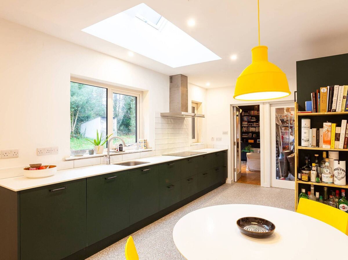 Bright new kitchen with overhead Velux and polished concrete effect floor tiles