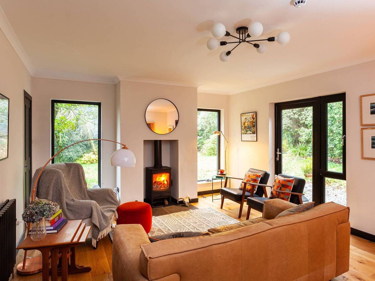 Double aspect living room with Charnwood wood-burning stove and woodland views