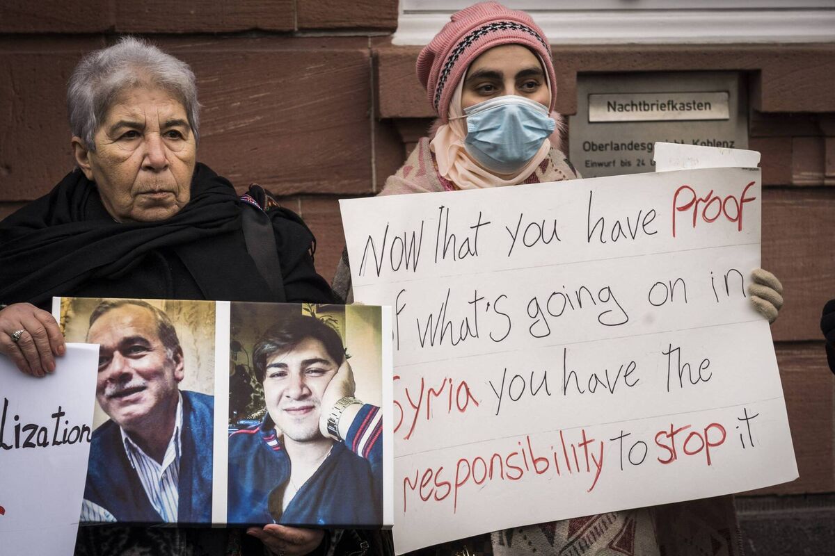 Women hold posters and photographs during a demonstration outside the courthouse where former Syrian intelligence officer Anwar Raslan stood on trial in Koblenz, Germany, on January 13, after the verdict was spoken on charges for crimes against humanity. Picture: Bernd Lauter/AFP via Getty Images)