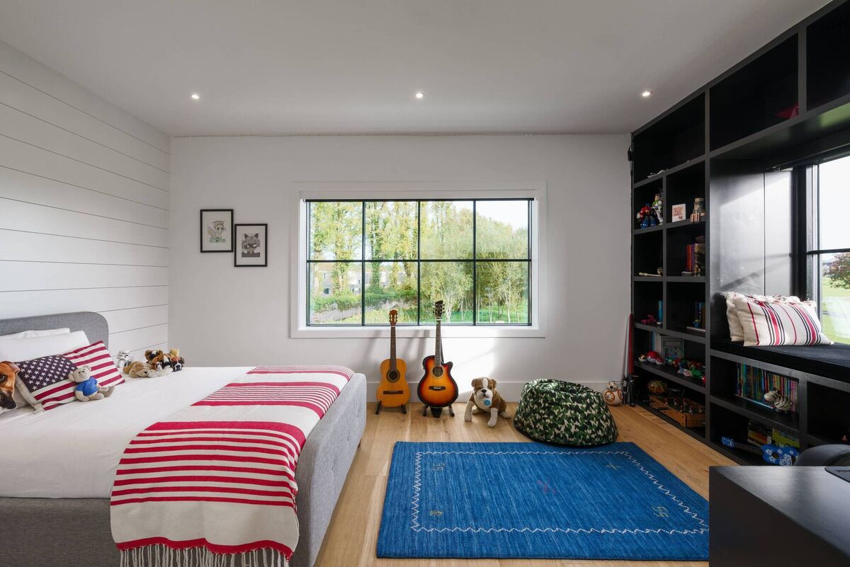 This bedroom features cabinetry for books, as well as farming a window reading nook. 