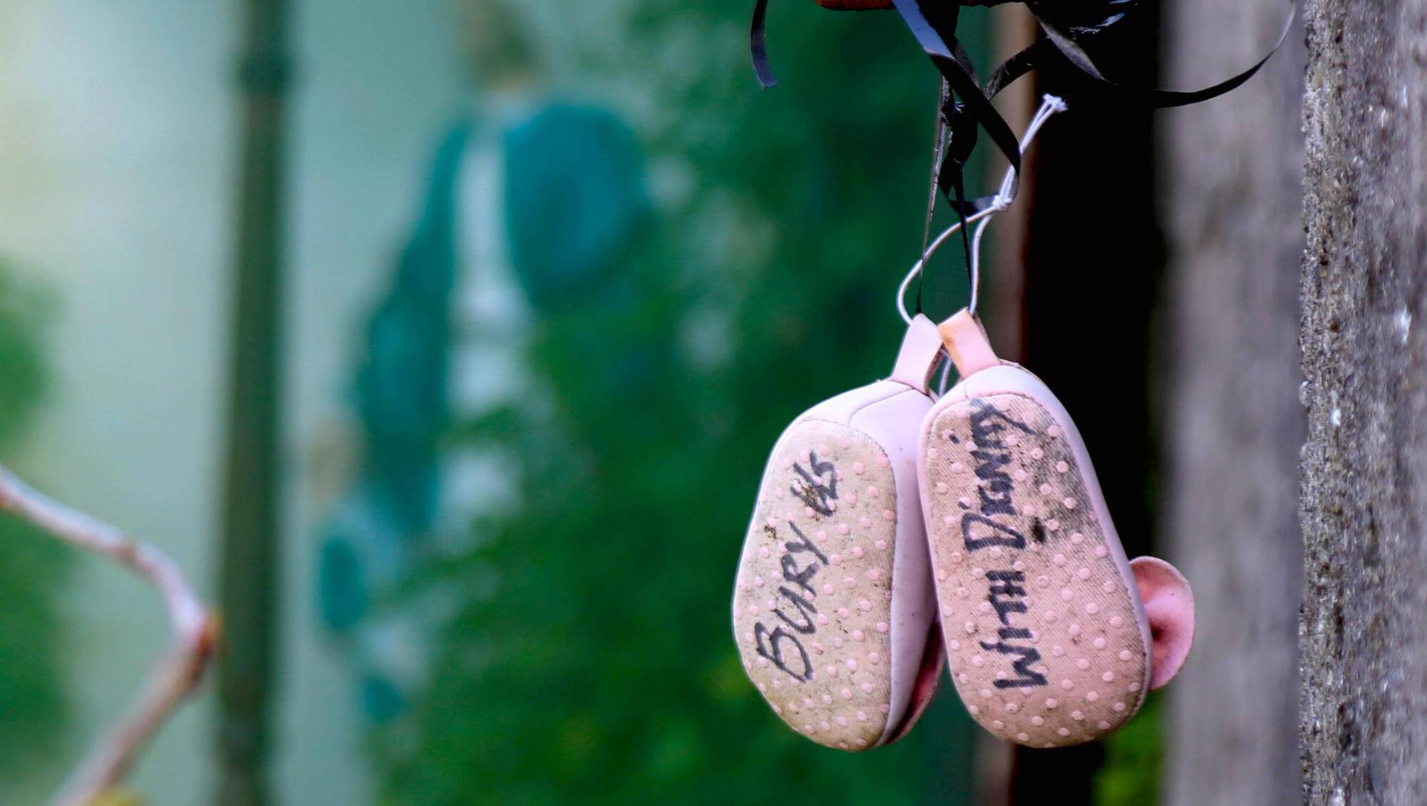 A pair of baby shoes with a massage hanging at the walls of the Mother and Baby home burial site in Tuam, Co Galway. 
