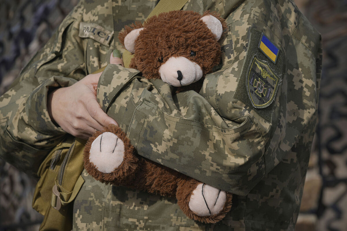 A Ukrainian servicewoman holds a teddy bear during a performance by Larisa Borisenko, for troops in eastern Ukraine. Picture: AP
                    