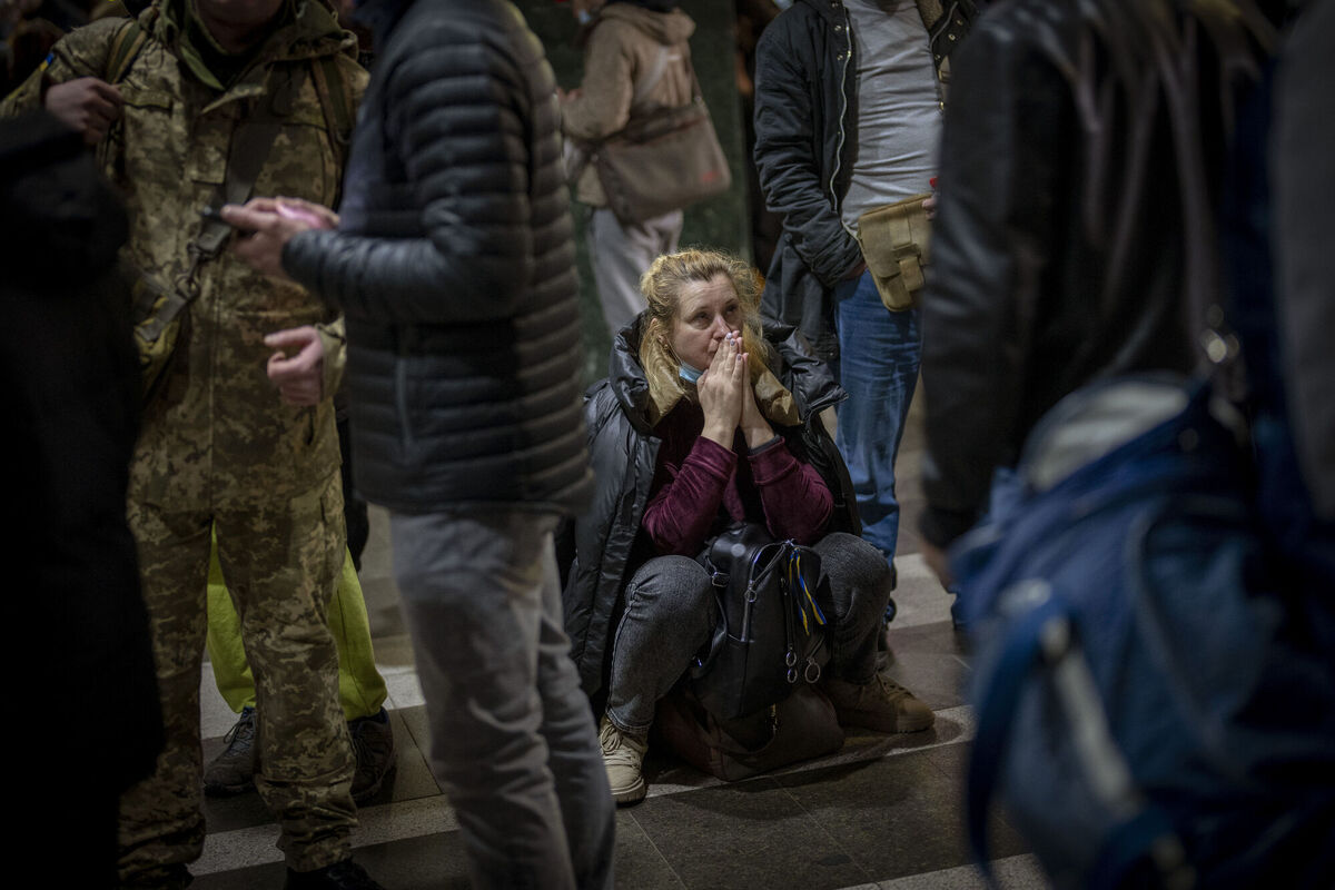 A woman reacts as she waits for a train trying to leave Kyiv, Ukraine. (AP Photo/Emilio Morenatti)