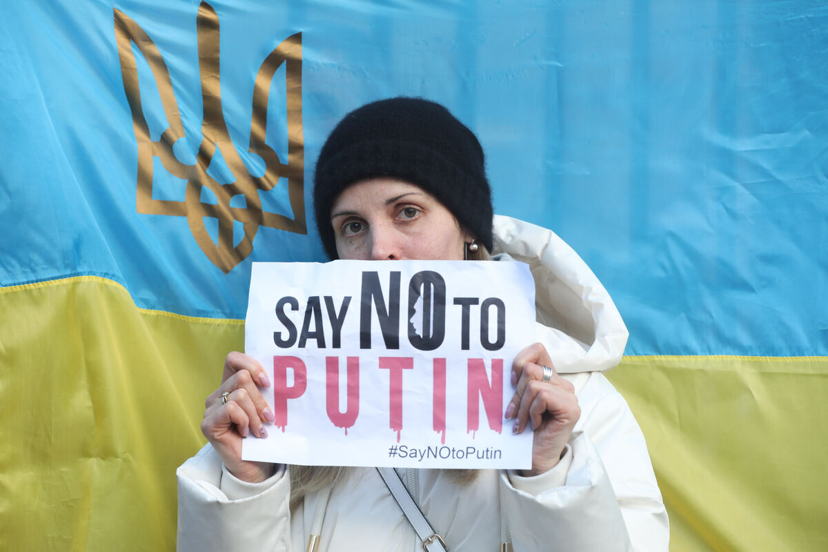 Tetiana Pavlova from Dubno in Ukraine holds up an anti-Putin sign as members of the Ukrainian community gather outside Leinster House at a protest against the Russian military invasion of Ukraine. Photographer: Leah Farrell/ Rollingnews.ie