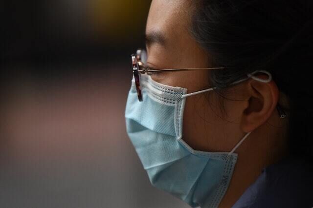 A woman wears a face mask (Victoria Jones/PA)