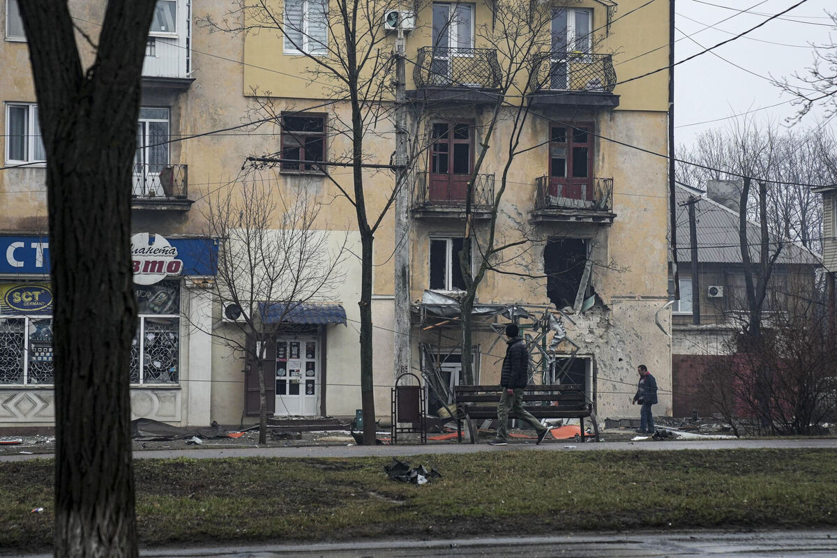 A man walks past an apartment building hit by shelling in Mariupol, Ukraine, Wednesday, March 2, 2022. (AP Photo/Evgeniy Maloletka)