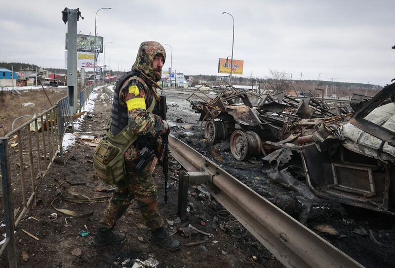 An armed man stands by the remains of a Russian military vehicle in Bucha, close to the capital Kyiv, Ukraine, Tuesday, March 1, 2022. Picture: AP Photo/Serhii Nuzhnenko An armed man stands by the remains of a Russian military vehicle in Bucha, close to the capital Kyiv, Ukraine, Tuesday, March 1, 2022. Picture: AP Photo/Serhii Nuzhnenko