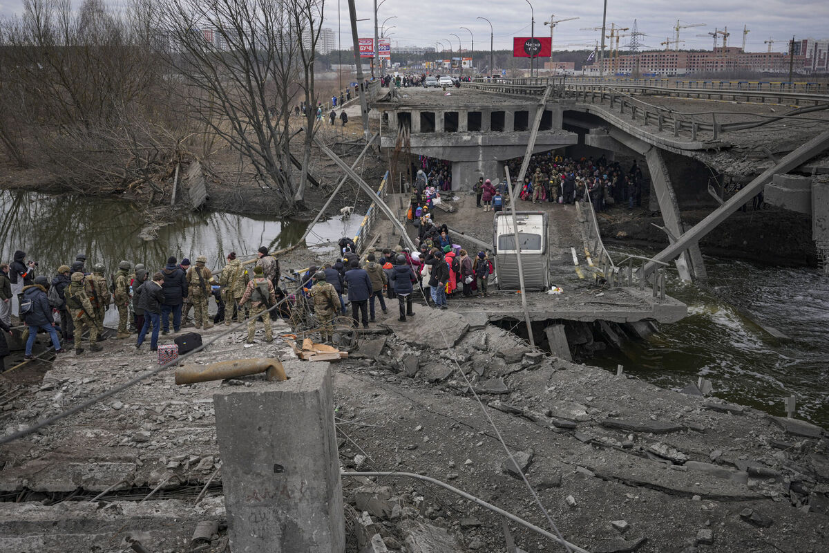 People cross on an improvised path under a bridge that was destroyed by a Russian airstrike while fleeing the town of Irpin. Picture: AP Photo/Vadim Ghirda People cross on an improvised path under a bridge that was destroyed by a Russian airstrike while fleeing the town of Irpin. Picture: AP Photo/Vadim Ghirda