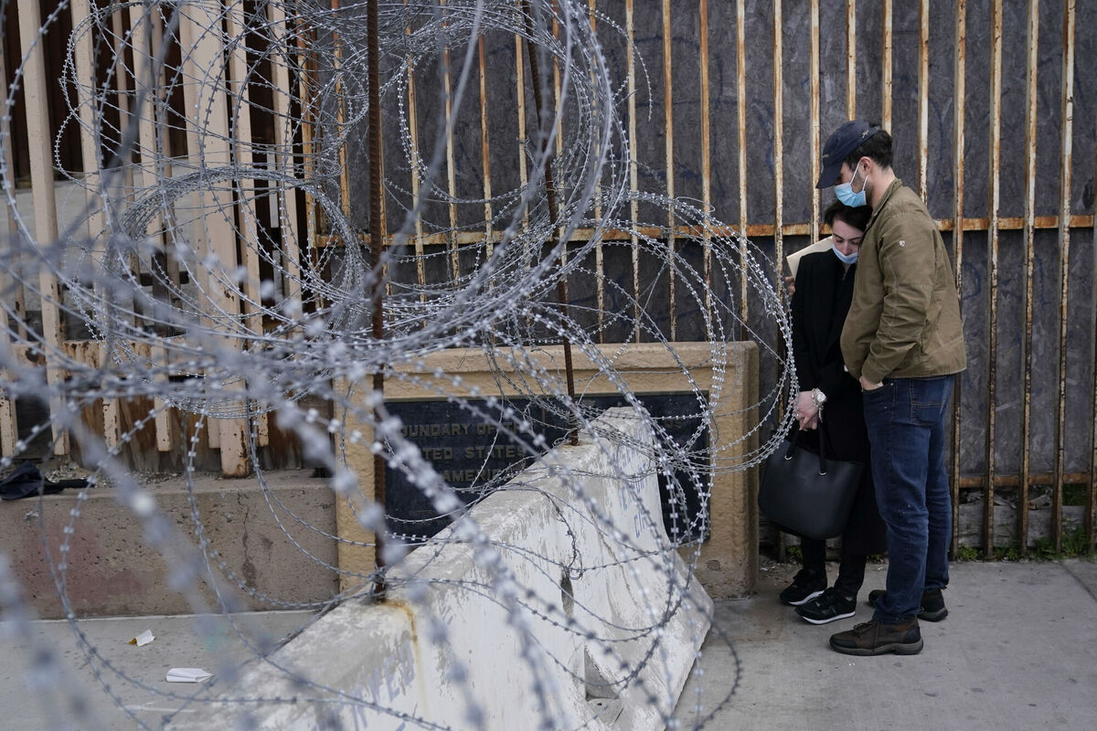A woman from Ukraine stands at the border with her fiancé from the United States as she waits to ask for asylum on Thursday in Tijuana, Mexico. Photo: AP/Gregory Bull A woman from Ukraine stands at the border with her fiancé from the United States as she waits to ask for asylum on Thursday in Tijuana, Mexico. Photo: AP/Gregory Bull