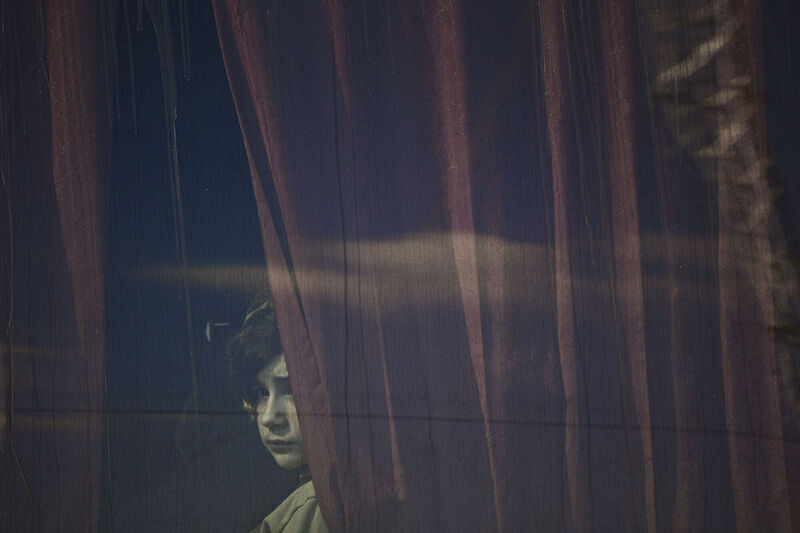 A refugee fleeing the war from neighbouring Ukraine looks out a bus window after crossing the border, at the Romanian-Ukrainian border in Siret. Picture: AP Photo/Andreea Alexandru