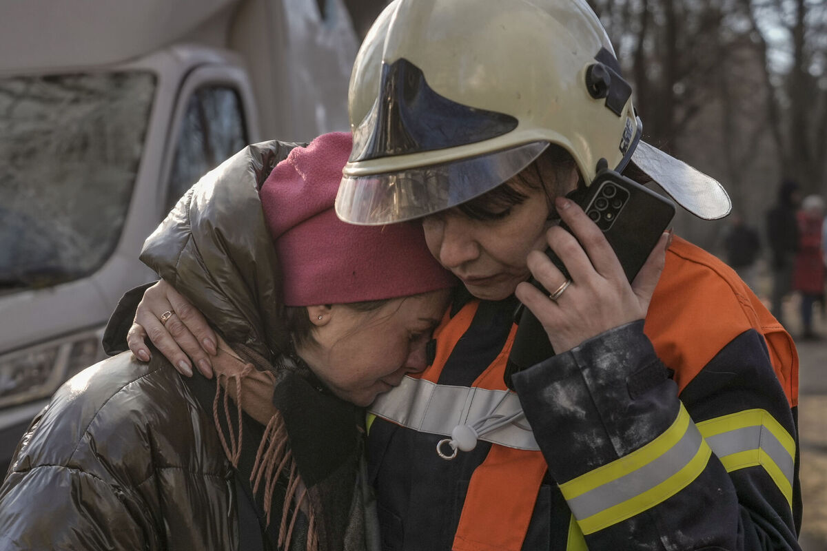 A firefighter comforts a woman outside a destroyed apartment building after a bombing in a residential area in Kyiv on Tuesday. A firefighter comforts a woman outside a destroyed apartment building after a bombing in a residential area in Kyiv on Tuesday.