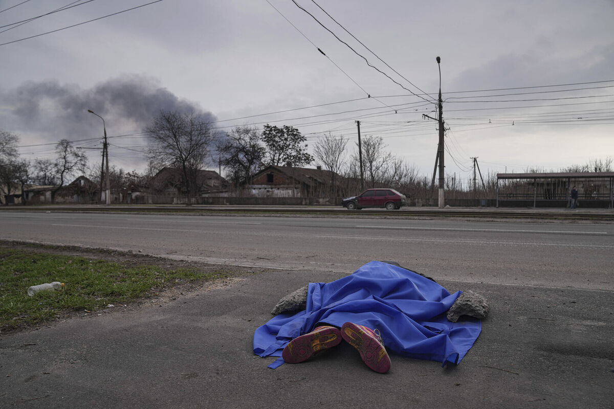A body lies covered by a tarp in the street in Mariupol, Ukraine, March 7, 2022. (AP Photo/Evgeniy Maloletka)