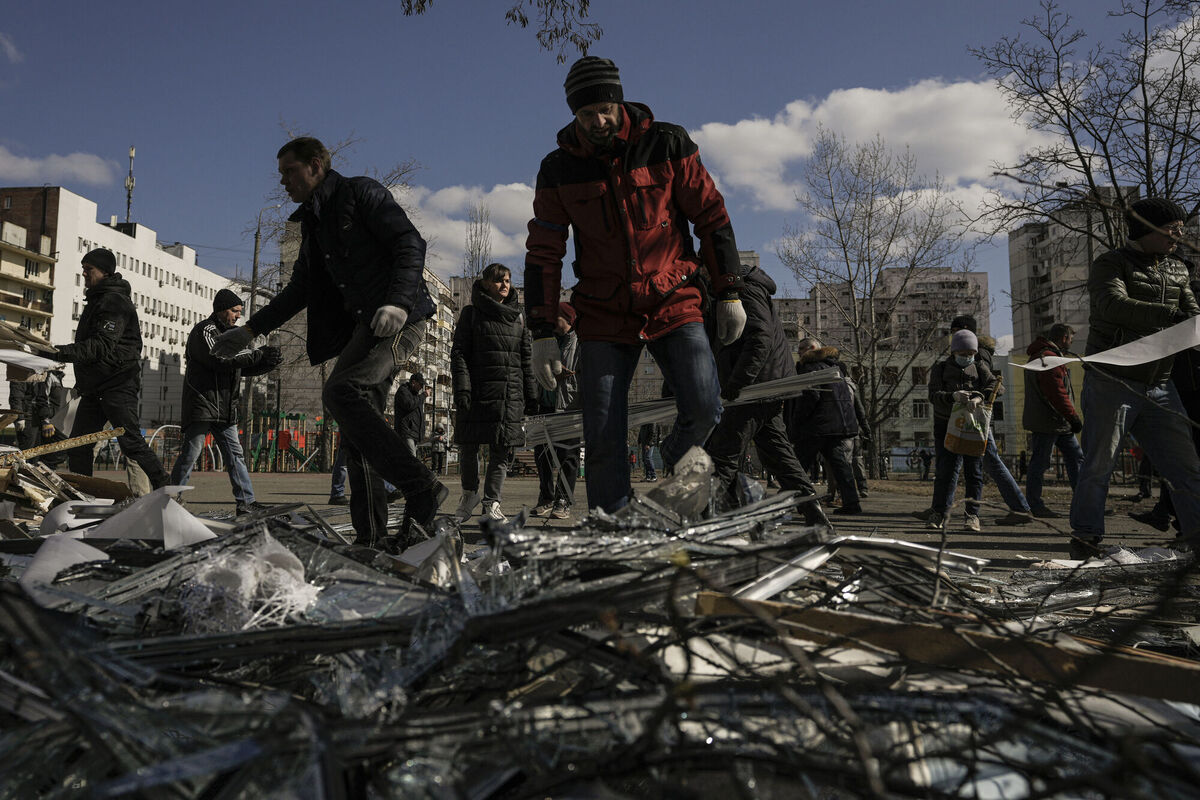 People clear debris outside a medical center damaged after parts of a Russian missile, shot down by Ukrainian air defense, landed on a nearby apartment block, according to authorities, in Kyiv, Ukraine. Picture: AP Photo/Vadim Ghirda