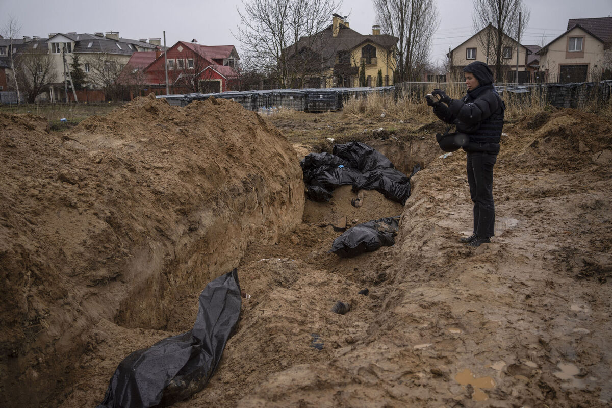 A journalist takes video of a mass grave in Bucha, on the outskirts of Kyiv, Ukraine, Sunday, April 3, 2022. Picture: AP Photo/Rodrigo Abd A journalist takes video of a mass grave in Bucha, on the outskirts of Kyiv, Ukraine, Sunday, April 3, 2022. Picture: AP Photo/Rodrigo Abd