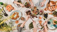 iStock-1148809207.jpg Peoples hands with various snacks and blooming mimosa, top view
