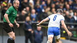 <p>17 April 2022; Darragh Lyons of Waterford handpasses the ball as referee Johnny Murphy looks on during the Munster GAA Hurling Senior Championship Round 1 match between Waterford and Tipperary at Walsh Park in Waterford. Photo by Piaras Ó Mídheach/Sportsfile</p>