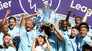 <p>Vincent Kompany, left, and Sergio Aguero, right, lift the Premier League trophy together (Martin Rickett/PA)</p>