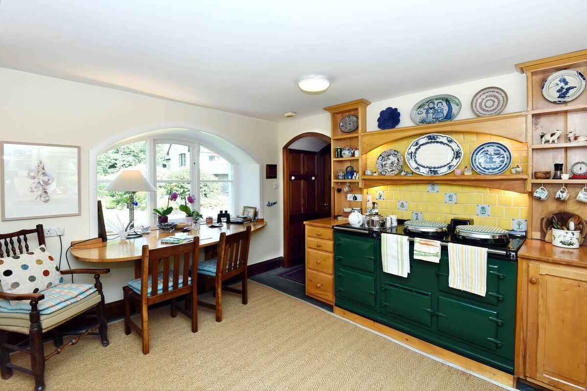 At home in the sunny kitchen by a warming green Aga