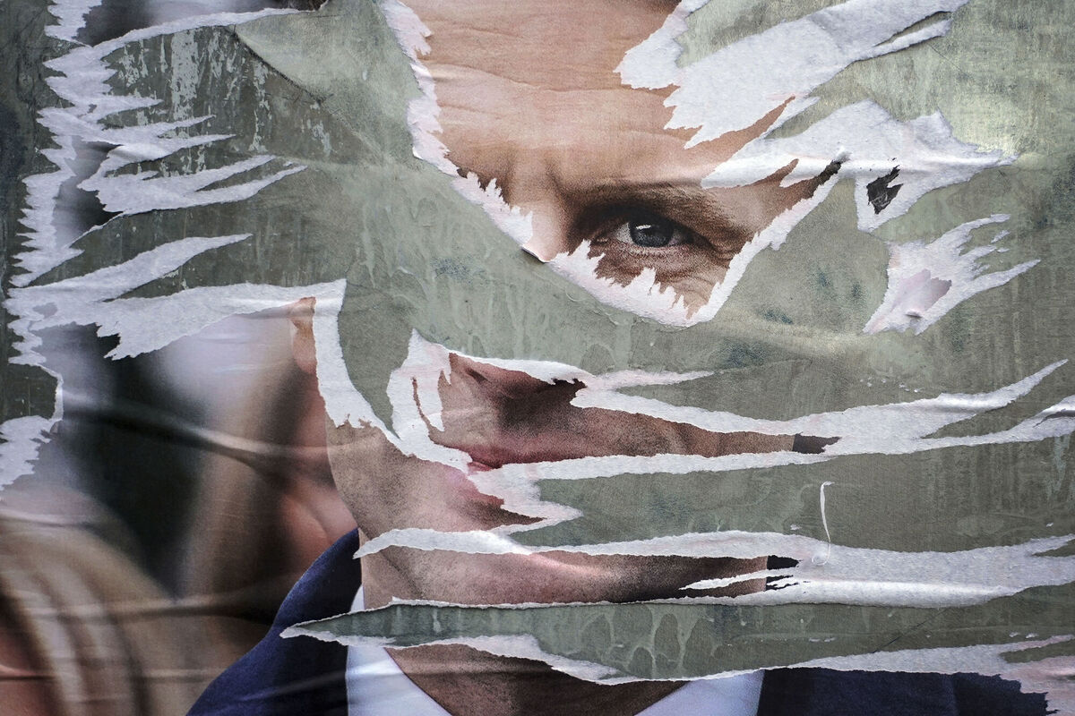 A ripped electoral poster of French President Emmanuel Macron. A ripped electoral poster of French President Emmanuel Macron.